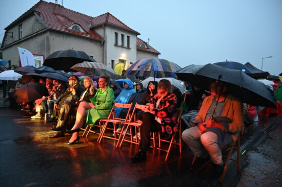 Publiczność pod parasolami