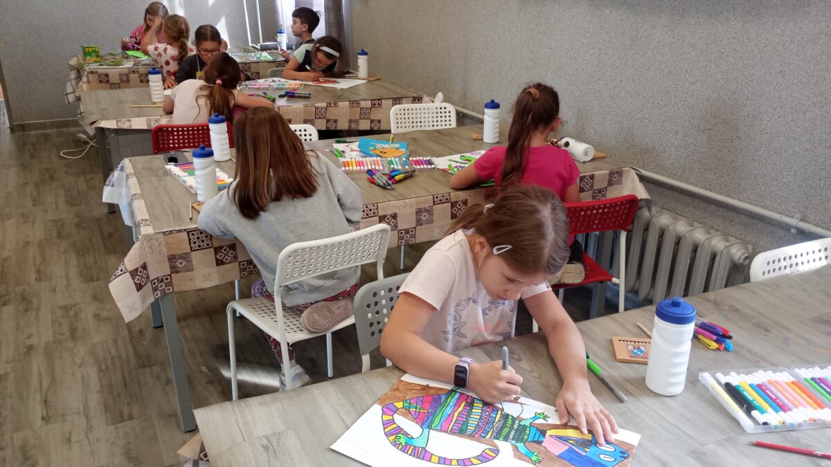 Dzieci malują przy stołach
